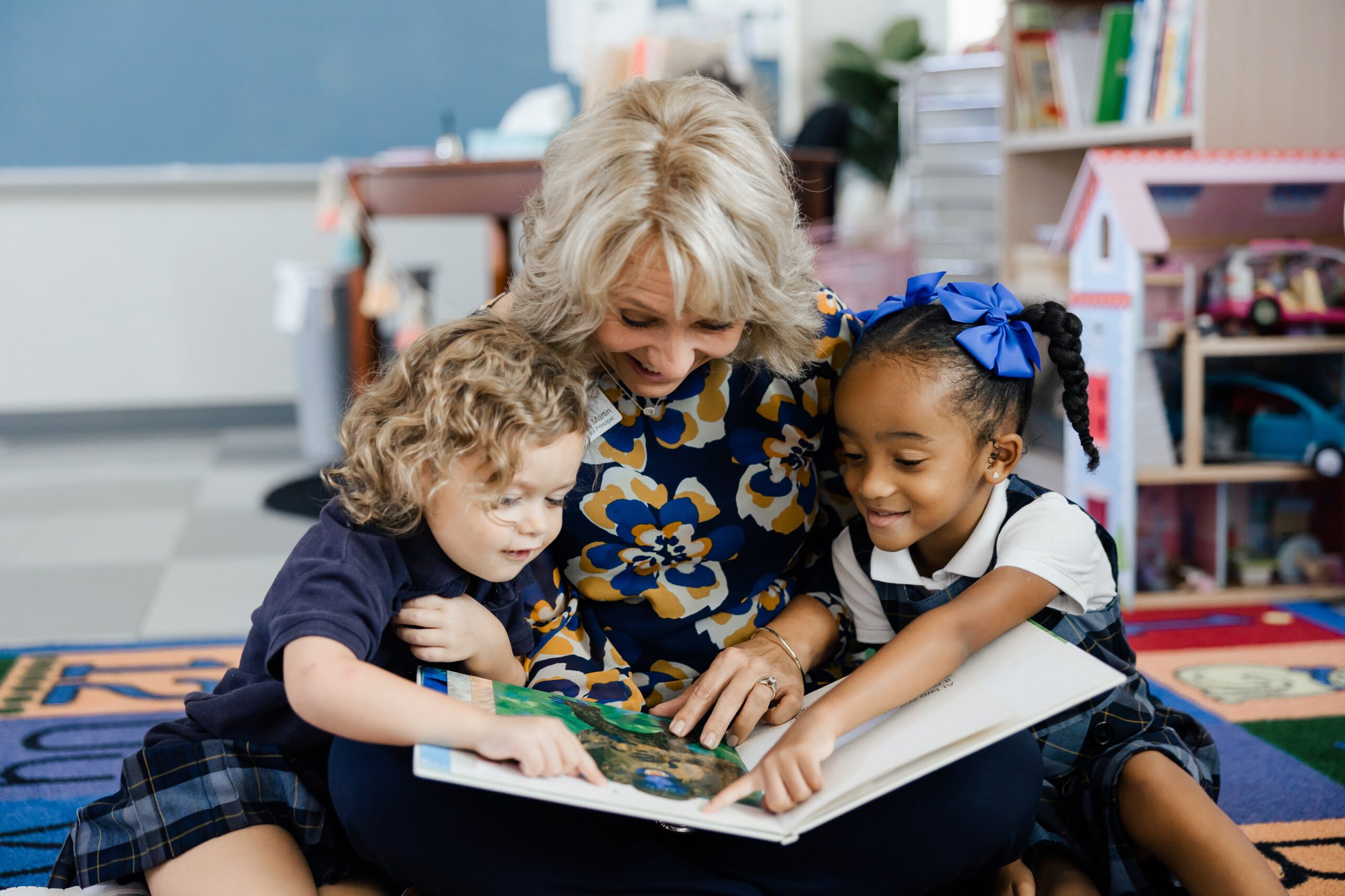 woman reading book with two children